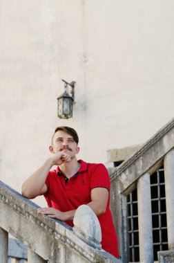 Koper, Slovenya. 25.06.2022. Genç ve yakışıklı sakallı adam, eski Koper şehrinde yürüyen bir turist. Yaz tatili. Güneş gözlüğü. Yaşam tarzı portresi