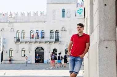 Koper, Slovenya. 25.06.2022. Genç ve yakışıklı sakallı adam, eski Koper şehrinde yürüyen bir turist. Yaz tatili. Güneş gözlüğü. Yaşam tarzı portresi