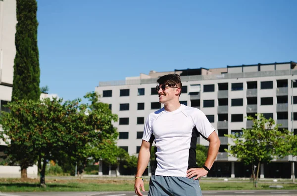 Genç, mutlu, sakallı adam, parkta oturan bir turist. Gülümsüyor, rahatlıyor. Yaz tatili. Güneş gözlüğü. Yaşam tarzı portresi. 