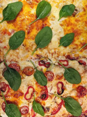 Background of vegetarian pizza with tomatoes, cheese, herbs, red pepper close up. Top view, flat lay. Restaurant menu. Unhealthy food. Fast food