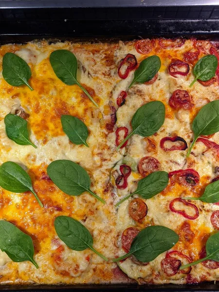 Background of vegetarian pizza with tomatoes, cheese, herbs, red pepper close up. Top view, flat lay. Restaurant menu. Unhealthy food. Fast food