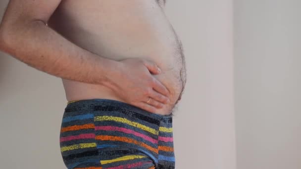 身穿内衣裤 腹部肥胖 体形超重的男人被白色背景隔离 体重减轻手术的概念 皮下脂肪分解 身体呈阳性腹部按摩 腹部包扎 — 图库视频影像