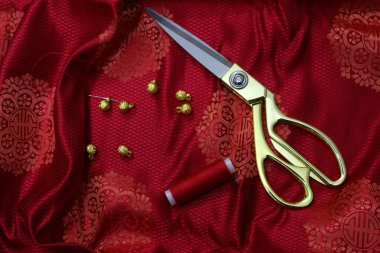 Düğmeleri, ipliği, iğnesi ve makası olan Moğol ipek kumaşı 