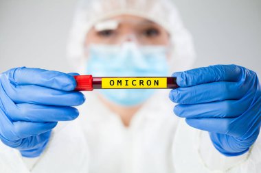 Doktor tıp çalışanı elinde hasta kan örneği içeren test tüpü tutucusu, SARS-CoV-2 Omicron varyantı konsepti, yeni Coronavirus virüs mutasyonu dünya çapında yeni COVID-19 salgın vakalarına neden oluyor.