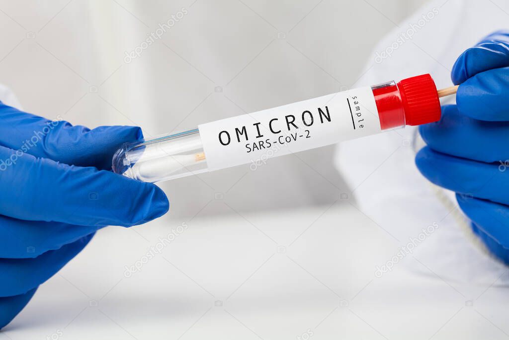 Medical NHS healthcare professional holding COVID-19 swab collection kit, wearing white PPE protective suit and gloves,test tube for taking Omicron patient specimen sample,PCR testing protocol process