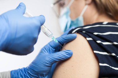 Mavi koruyucu eldivenlerle tıbbi işçilerin ellerinin kapatılması yaşlı hastanın omzuna aşı enjekte eden Coronavirus aşısı COVID-19 virüs hastalığına karşı, dokunulmazlık sertifikası