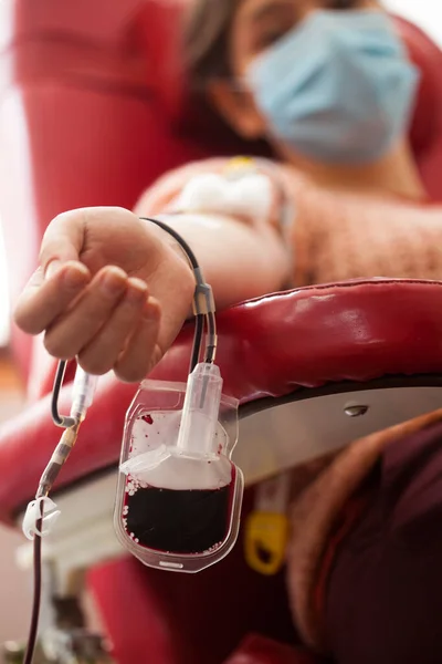 病院や研究室で血液を寄付若い女性 焦点で血液袋と椅子に座って 同時Covid 19患者の血漿交換の概念 善意と善意が必要としている他の人を助けます — ストック写真