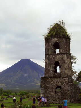Filipinler 'in Legazpi yakınlarındaki Cagsawa harabelerinde Mayon Dağı' nın önündeki tarihi çan kulesi. 18 Ocak 2012