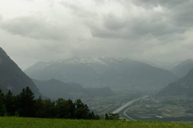 Triesenberg, Lihtenştayn, 20 Haziran 2021 Alpler ve Ren Vadisi manzarası bulutlu bir günde