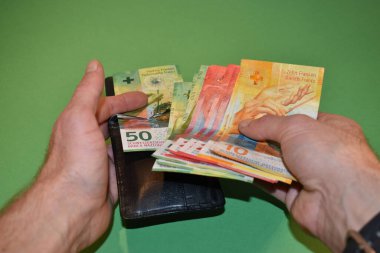 Vaduz, Lihtenştayn, 22 Kasım 2021 Bir cüzdanın İsviçre para biriminden bir kaç banknot çıkardı