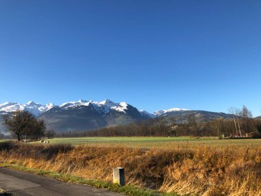 Schaan, Lihtenştayn, 9 Kasım 2021. Kar, güneşli bir günde güzel bir kırsalın arkasındaki dağ zirvelerini kapladı.
