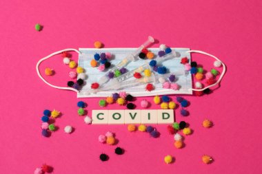 Vaduz, Lihtenştayn, 17 Aralık 2021 Virüs parçacıkları tıbbi yüz maskelerinde şırıngalarla ve Covid yazısıyla