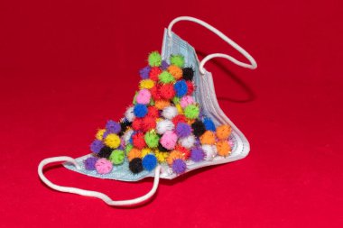 Vaduz, Lihtenştayn, 17 Aralık 2021 Kırmızı arka planda farklı virüs varyasyonları olan tıbbi yüz maskesi