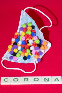 Vaduz, Lihtenştayn, 17 Aralık 2021 Kırmızı arka planda farklı virüs varyasyonları olan tıbbi yüz maskesi