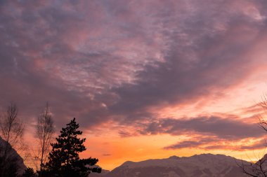 Vaduz, Lihtenştayn, 14 Aralık 2021 Dağların üzerinden gün batımından sonra Majestic bulut manzarası