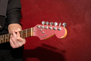 Vaduz, Lihtenştayn, 11 Ocak 2022 Fender Stratocaster ABD elektro gitarı. Burgonya sisi renginde 1995 yapımı bir kafa fotoğrafı.