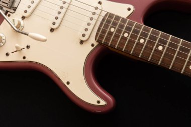 Vaduz, Lihtenştayn, 11 Ocak 2022 Nadir bulunan bir Stratocaster ABD elektro gitarının çekimi. 1995 'te Burgundy Sis renginde üretilmiş.