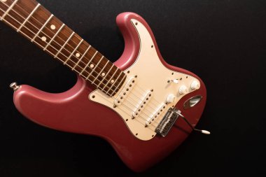 Vaduz, Lihtenştayn, 11 Ocak 2022 Nadir bulunan bir Stratocaster ABD elektro gitarının çekimi. 1995 'te Burgundy Sis renginde üretilmiş.