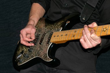 Vaduz, Lihtenştayn, 12 Ocak 2022 Müzisyen Fender Stratocaster Richie Sambora marka siyah şal desenli elektro gitar ile sahne alıyor.