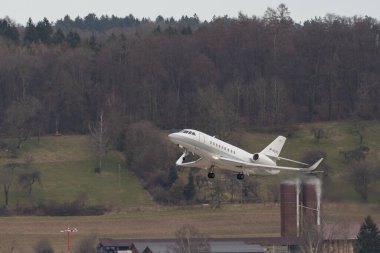 Zürih, İsviçre, 24 Şubat 2022 Dessault Falcon 2000LX uçağı 28 numaralı pistten kalkıyor.