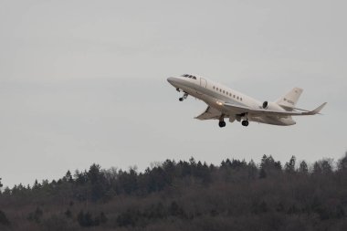 Zürih, İsviçre, 24 Şubat 2022 Dessault Falcon 2000LX uçağı 28 numaralı pistten kalkıyor.