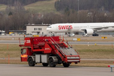 Zürih, İsviçre, 24 Şubat 2022 İsviçre İtfaiyesi kamyonu önlüğündeki bir Boeing 777-300ER 'in önünde.