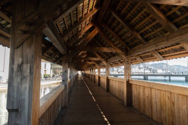 Lucerne, İsviçre, 10 Mart 2022 'de şehir merkezindeki meşhur eski ve ahşap şapel köprüsünün içinde yaya geçidi.