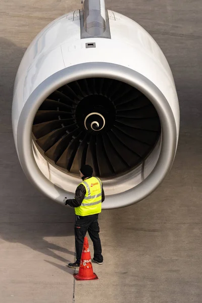 Zürih, İsviçre, 2 Mart 2022 Bir çalışan önlükteki Airbus A321 uçağının motorunu kontrol ediyor.