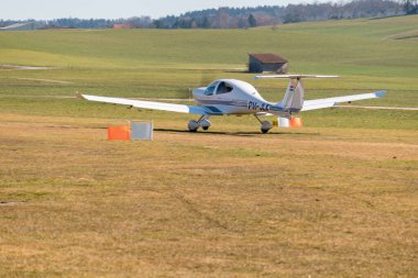 Lommis, İsviçre, 27 Şubat 2022 Diamond DA-40 pervane uçağı çimen pistinden kalkıyor.