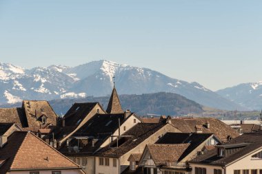 Rapperswil, İsviçre. 27 Şubat 2022. Arka planda görkemli kar yağışı ile çatıda görüldü.