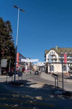 Davos, İsviçre, 23 Mart 2022 Güneşli bir günde arka planda Alpler olan bir sokak köşesine bakın.