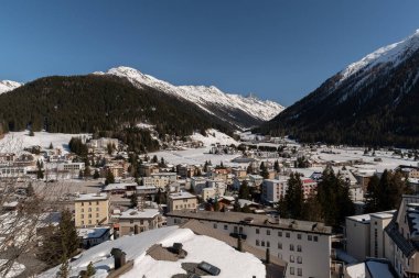 Davos, İsviçre, 23 Mart 2022 Şehre bakan büyüleyici kar yağışı açık mavi gökyüzünü kapladı.
