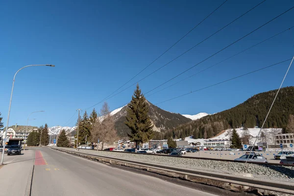 ダボス スイス 2022年3月23日車の駐車場と晴れた日の背景にアルプスと道路に沿って列車のトラックシステム — ストック写真