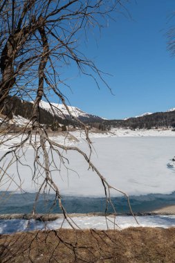 Davos, İsviçre, 23 Mart 2022 Donmuş göl manzarası ve güneşli bir günde Alp manzarası