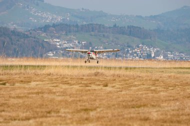 Wangen-Lachen, İsviçre, 27 Mart 2022 Piper PA22-150 Karayip pervane uçağı küçük bir havaalanına iniyor.