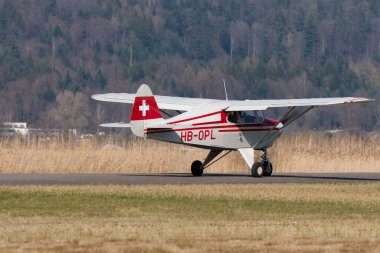 Wangen-Lachen, İsviçre, 27 Mart 2022 Piper PA22-150 Karayip pervane uçağı küçük bir havaalanındaki konumuna doğru ilerliyor.