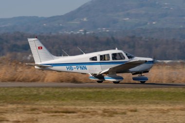 Wangen-Lachen, İsviçre, 27 Mart 2022 Piper PA28-161 Savaşçı II pervane uçağı küçük bir havaalanındaki konumuna doğru ilerliyor.