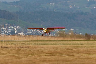 Wangen-Lachen, İsviçre, 27 Mart 2022 Piper PA18-180M Super Cub pervaneli uçak küçük bir havaalanına iniyor.