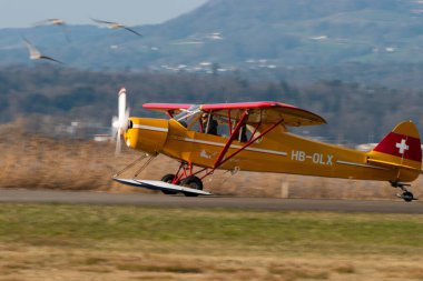 Wangen-Lachen, İsviçre, 27 Mart 2022 Piper PA18-180M Super Cub pervaneli uçak küçük bir havaalanına iniyor.