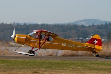 Wangen-Lachen, İsviçre, 27 Mart 2022 Piper PA18-180M Super Cub pervaneli uçak küçük bir havaalanına iniyor.