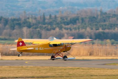 Wangen-Lachen, İsviçre, 27 Mart 2022 Piper PA18-180M Super Cub pervaneli uçak küçük bir havaalanından kalkıyor.