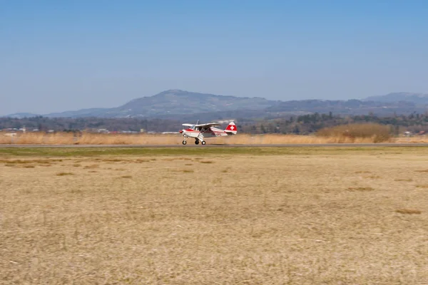 Wangen-Lachen, İsviçre, 27 Mart 2022 Piper PA22-150 Karayip pervane uçağı küçük bir havaalanına iniyor.