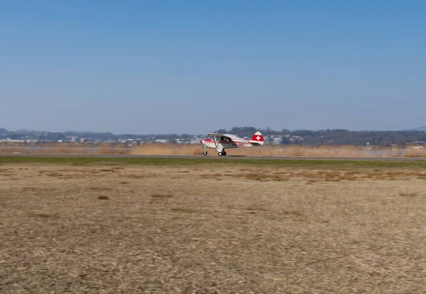 Wangen-Lachen, İsviçre, 27 Mart 2022 Piper PA22-150 Karayip pervane uçağı küçük bir havaalanına iniyor.