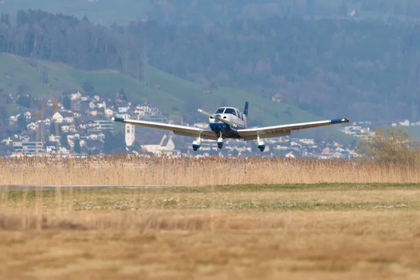 Wangen-Lachen, İsviçre, 27 Mart 2022 Piper PA28-181 Archer III pervane uçağı küçük bir havaalanına iniyor.