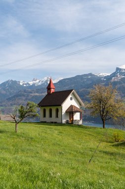 Weesen, İsviçre, 13 Nisan 2022 Walensee gölündeki küçük katolik şapeli. Baharda arka planda görkemli Alpler var.