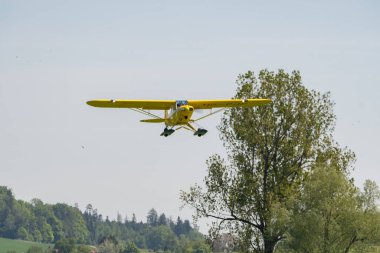Lommis, İsviçre, 11 Mayıs 2022 Sarı Piper PA18-150 Süper Cub pervaneli uçak küçük bir havaalanından kalkıyor.