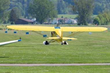 Lommis, İsviçre, 11 Mayıs 2022 Piper PA18-150 Süper Cub pervaneli uçak çimlerin üzerinde küçük bir havaalanında
