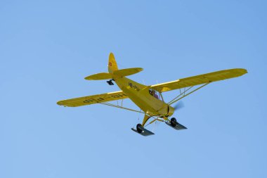 Lommis, İsviçre, 11 Mayıs 2022 Sarı Piper PA18-150 Süper Cub pervaneli uçak küçük bir havaalanından kalkıyor.