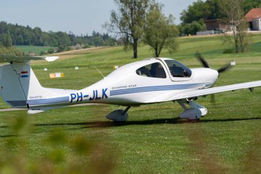 Lommis, İsviçre, 11 Mayıs 2022 Diamond DA40D pervane uçağı küçük bir havaalanındaki çimlerin üzerinde taksicilik yapıyor.