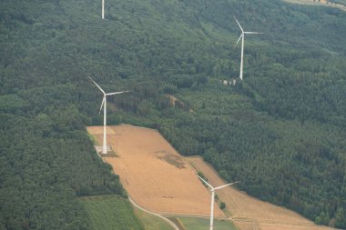 Collenberg, Bavaria, Germany, July 10, 2022 Wind energy turbines are rotating on a green hill seen from a small plane